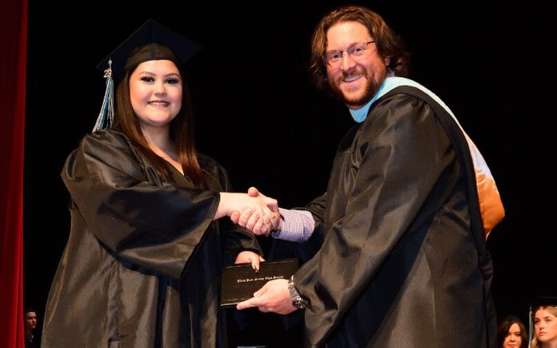 Alumnos graduados dándose la mano