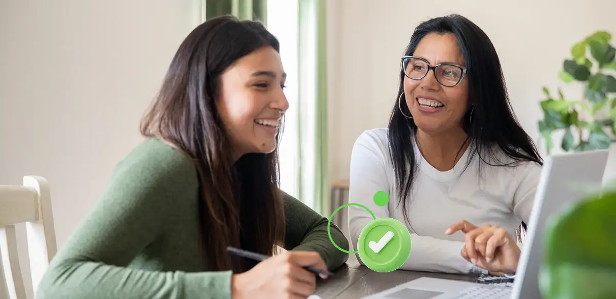 Madre e hija trabajando juntas con su ordenador portátil.
